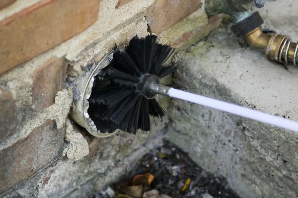 A white air vent is hanging from the ceiling of a building.