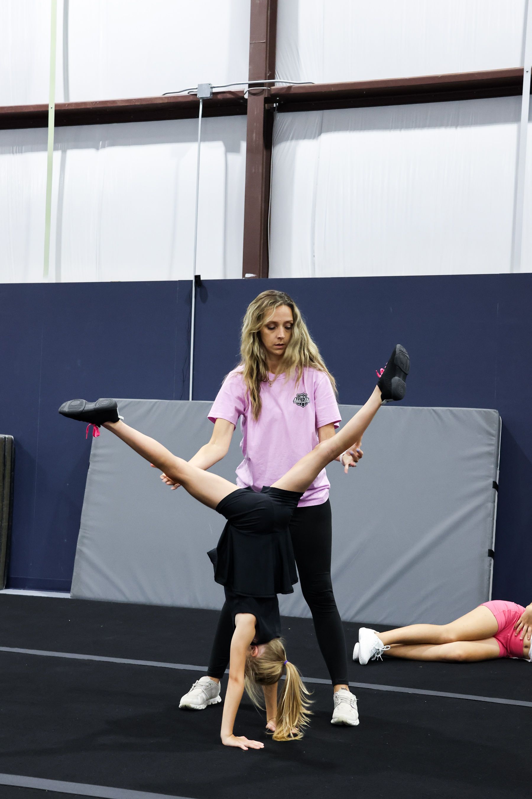 A group of children are dancing in front of a mirror in a dance studio.