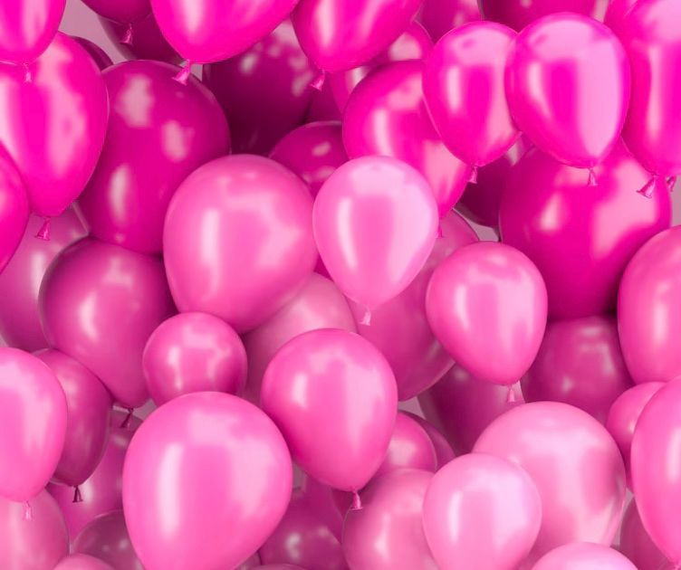 A bunch of pink balloons are floating in the air.