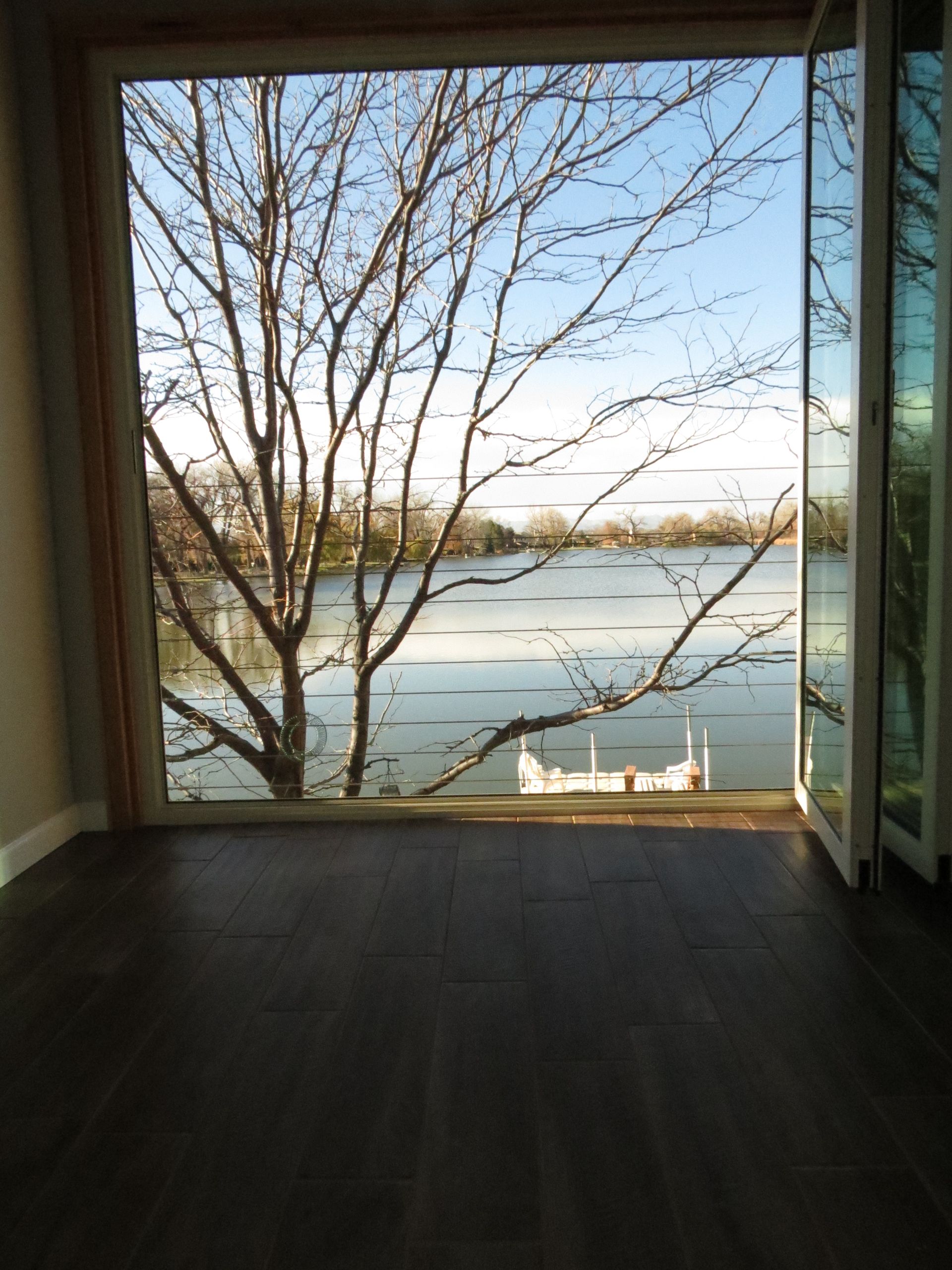An empty room with a view of a lake through a window