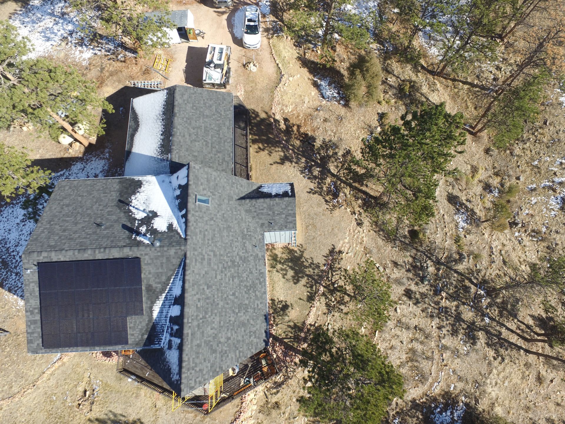 An aerial view of a house with solar panels on the roof