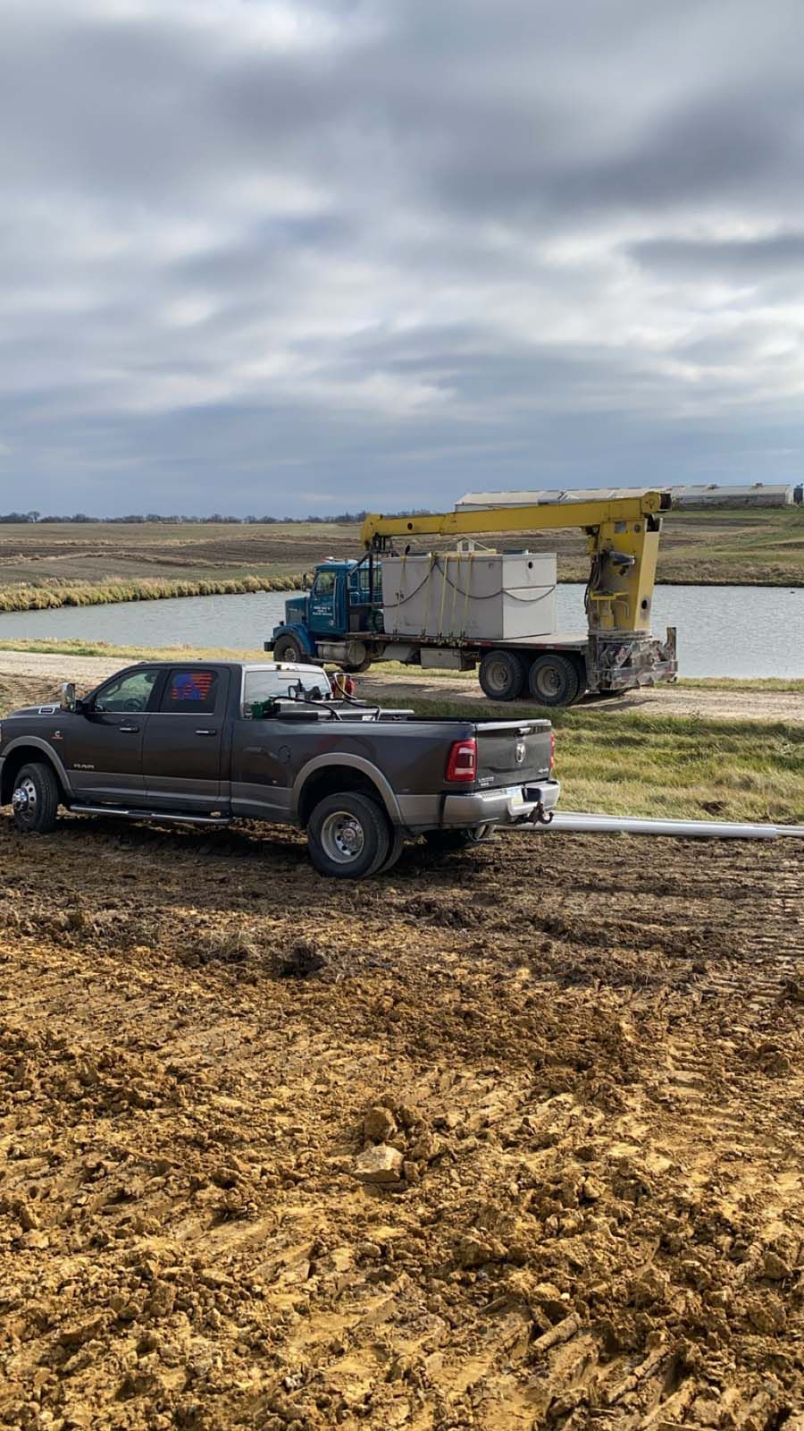 A truck is towing a large truck in a muddy field.