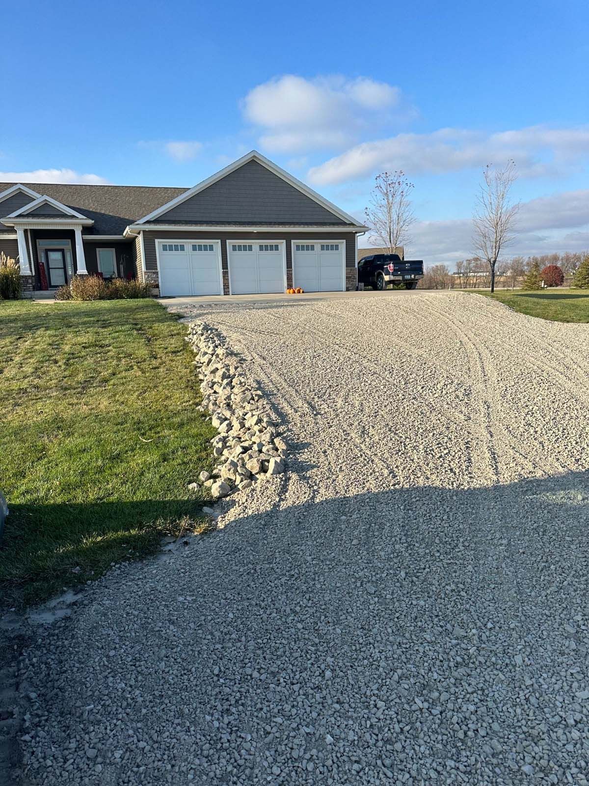 There is a gravel driveway leading to a house.