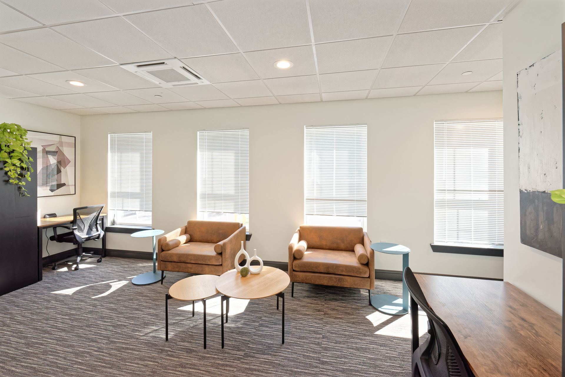 a living room with a couch , chairs , tables and a desk .