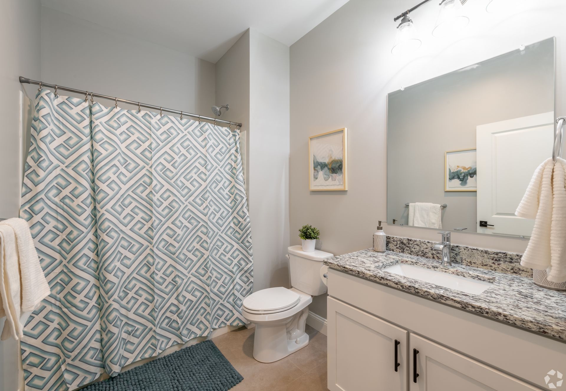 a bathroom with a toilet , sink , and shower curtain .