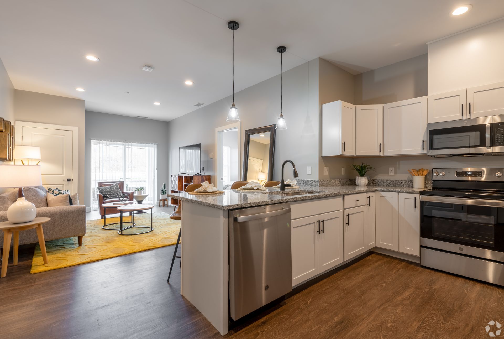 a kitchen with white cabinets , stainless steel appliances , and a large island .