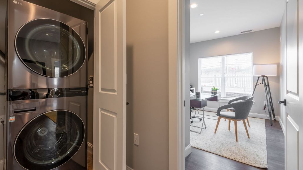 a laundry room with a washer and dryer stacked on top of each other .