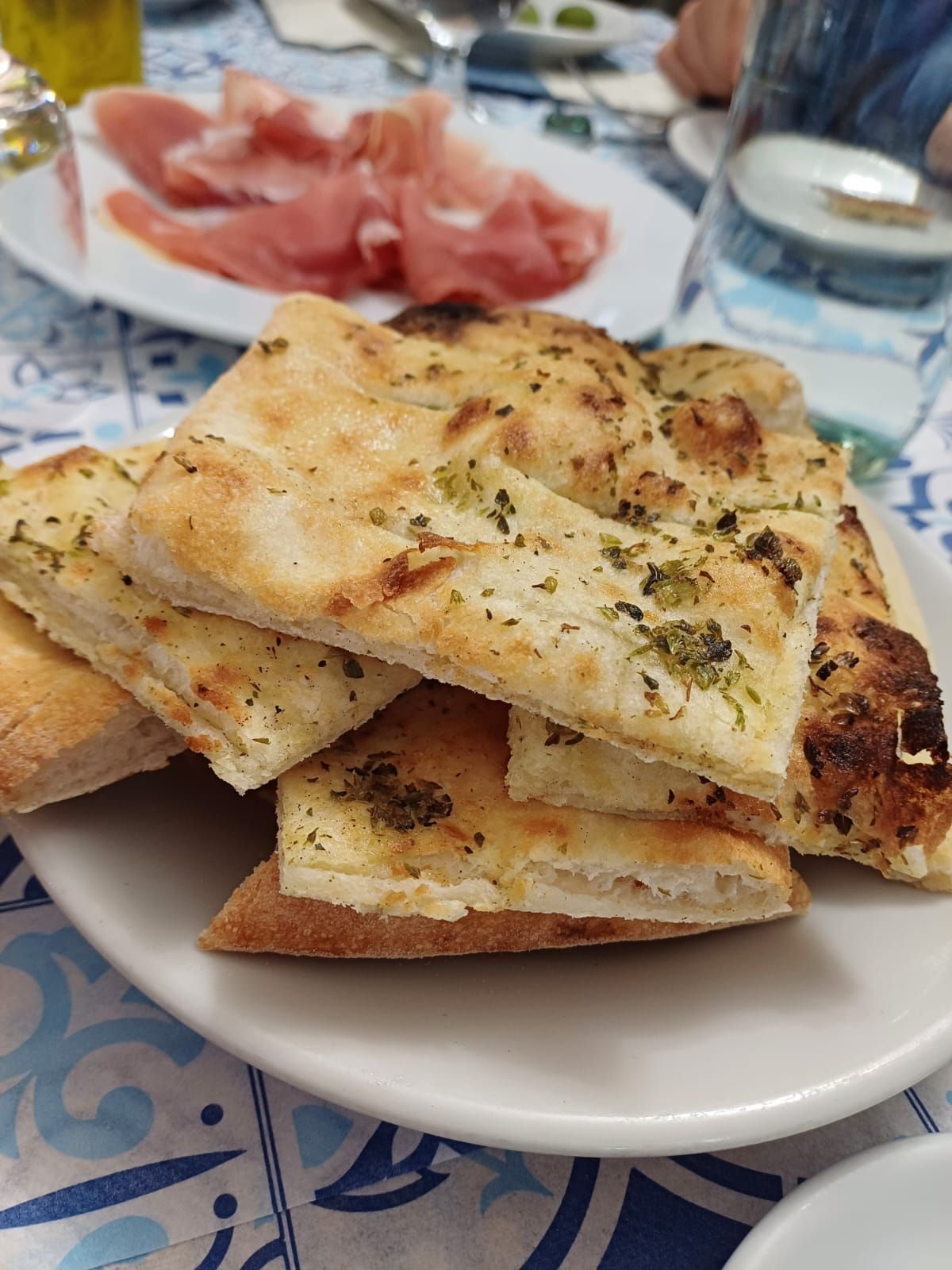 Una bottiglia di vino è appoggiata accanto a una ciotola di cibo su un tavolo.