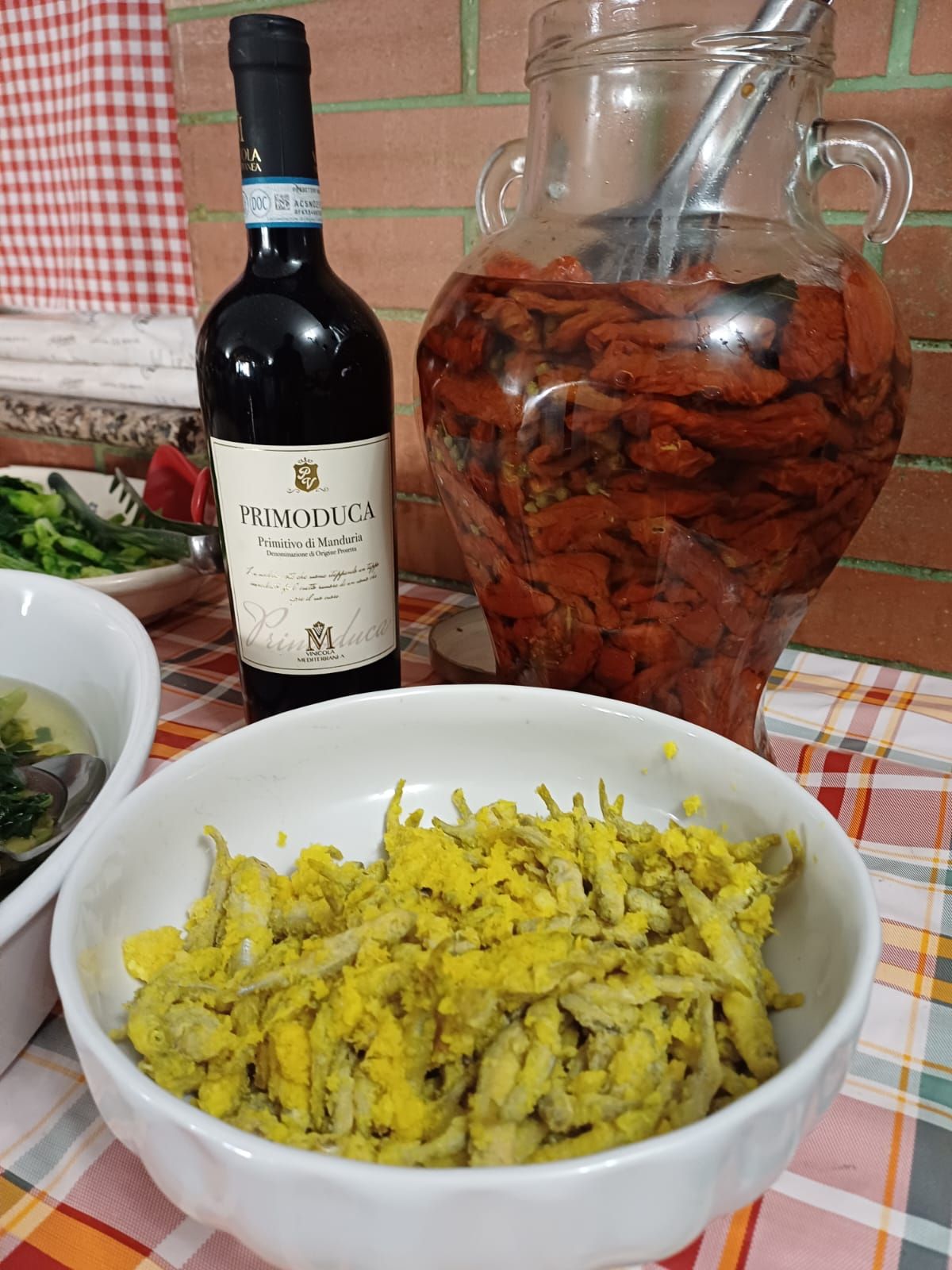 Una bottiglia di vino è appoggiata accanto a una ciotola di cibo su un tavolo.