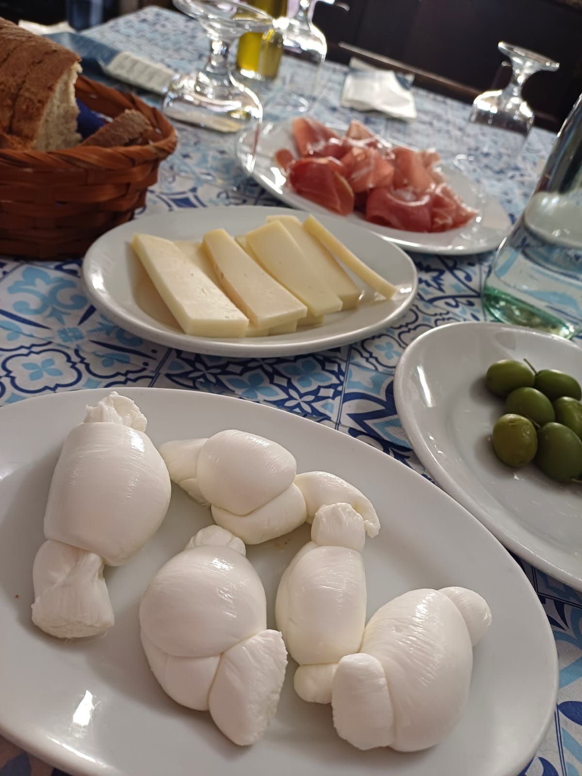 Un tavolo sormontato da piatti di cibo, tra cui formaggio e olive.
