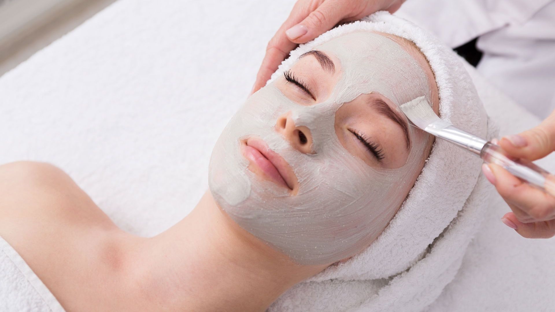 A woman is getting a facial treatment at a spa.
