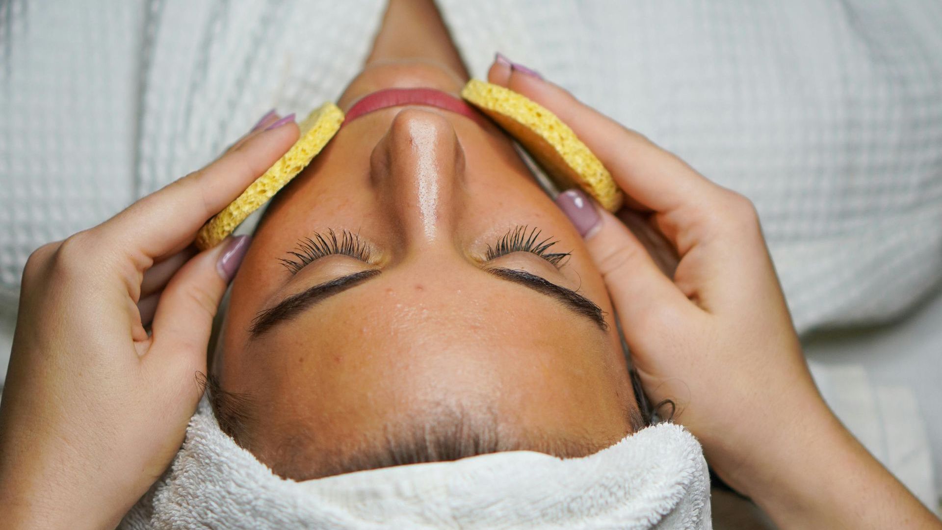 A woman is getting a facial treatment at a spa.