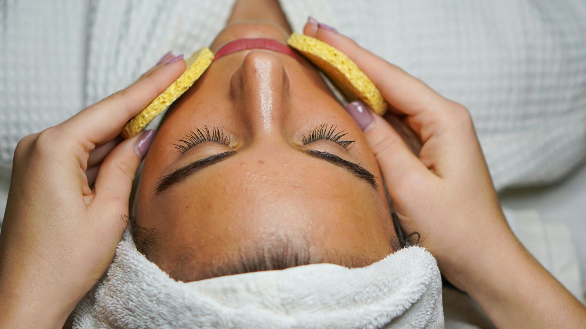 A woman with a towel around her head is getting a massage