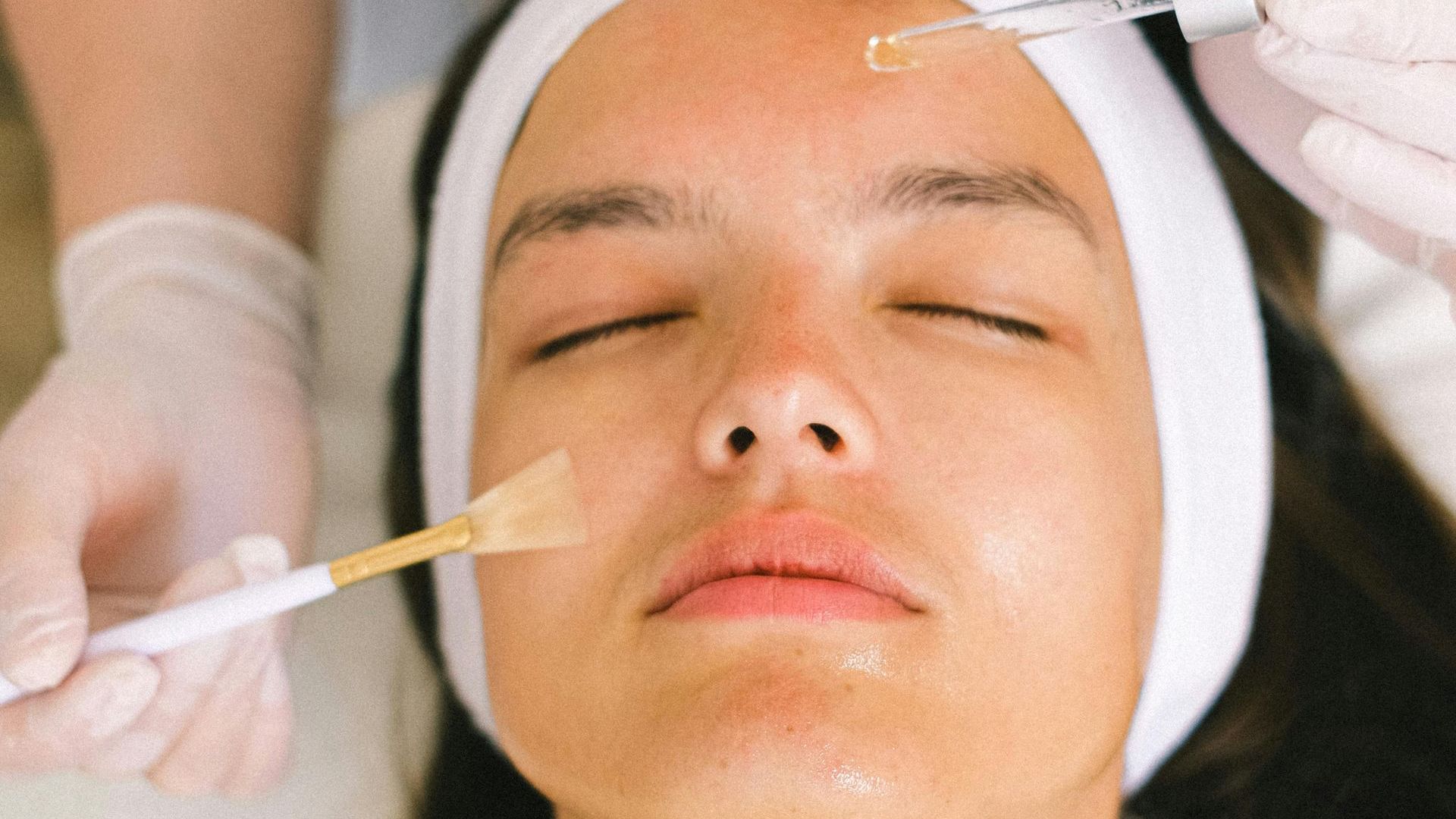 A woman is getting a facial treatment at a beauty salon.
