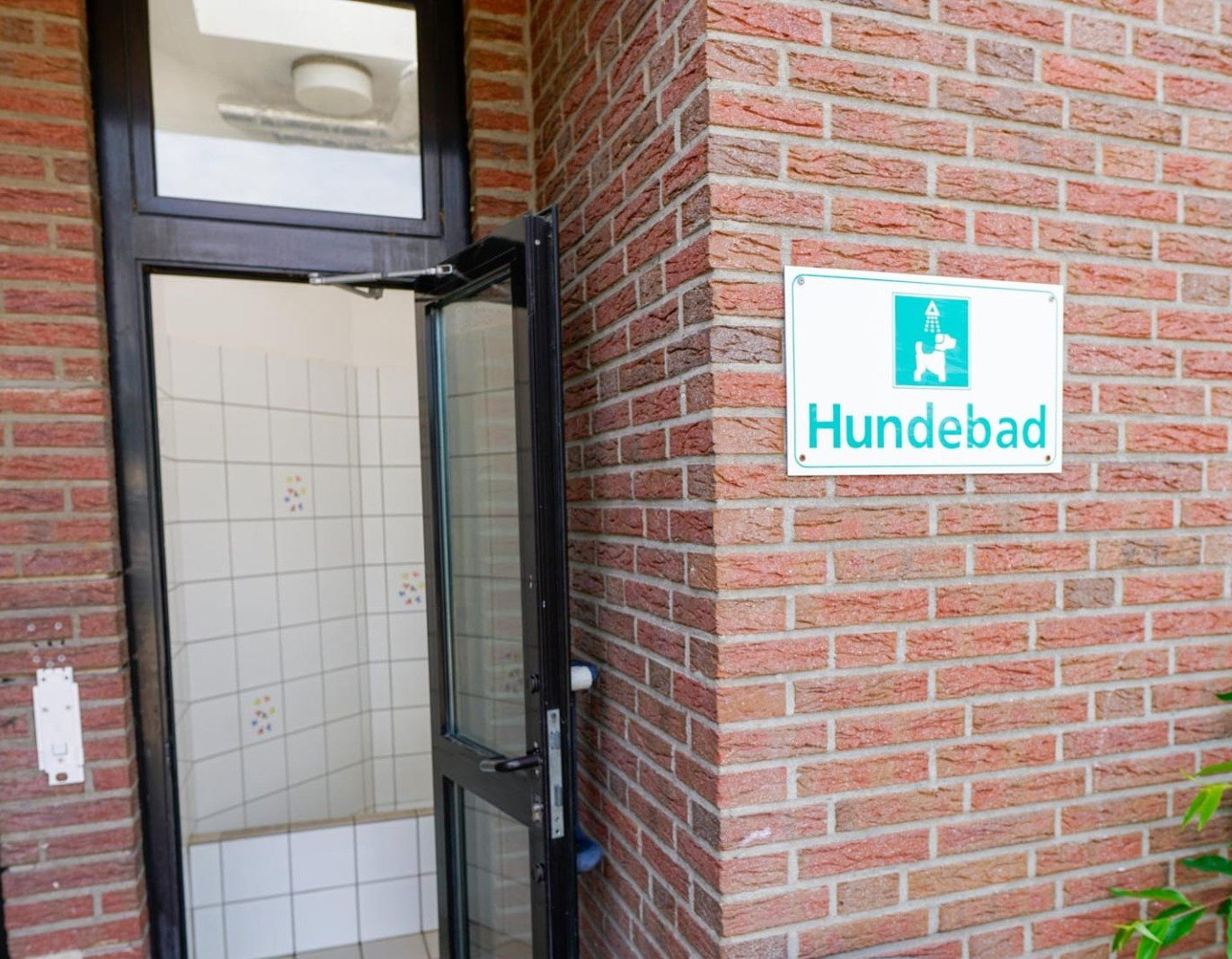 Außenansicht eines Gebäudes mit einem Schild mit der Aufschrift „Hundebad“. 