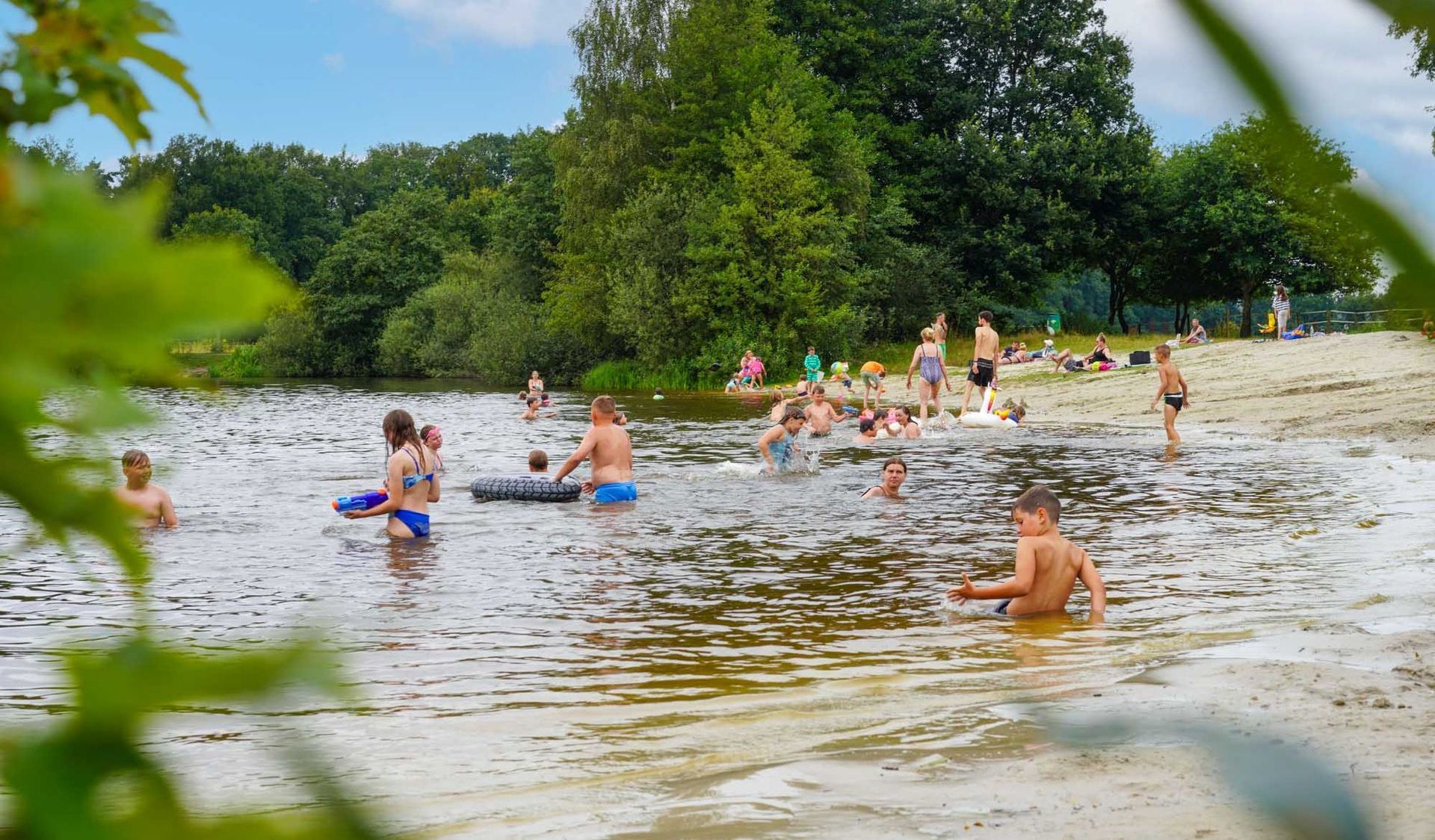 Menschen schwimmen und spielen an einem sonnigen Tag in einem See