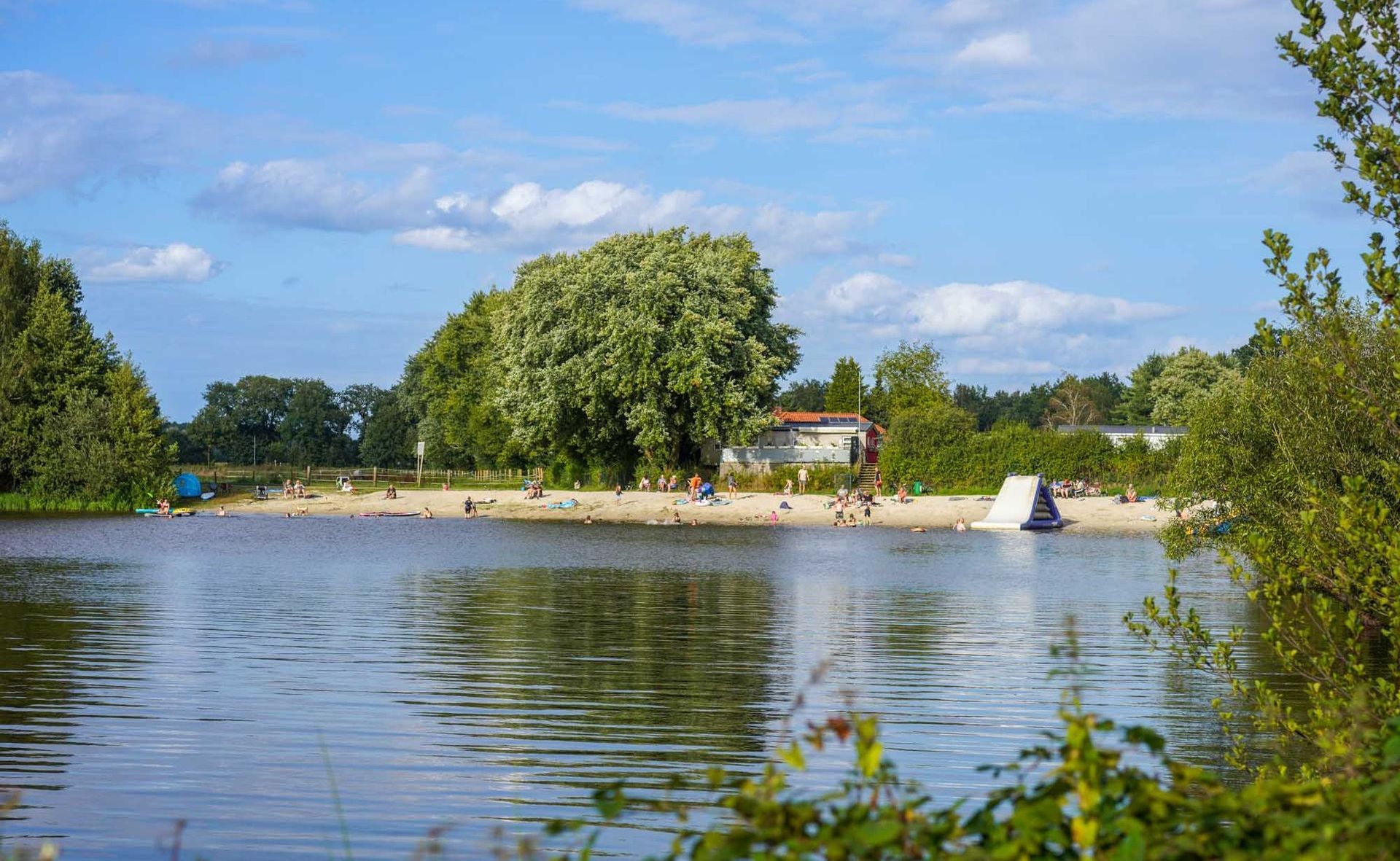 Seelandschaft mit Sandstrand und Menschen, die sich entspannen.