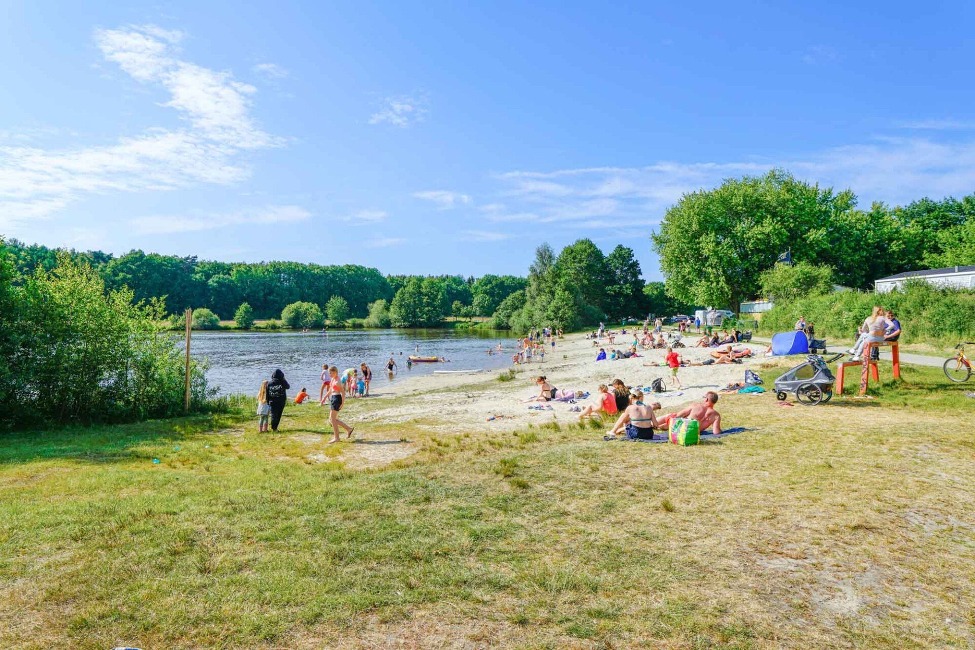 Menschen an einem Sandstrand in der Nähe eines Sees