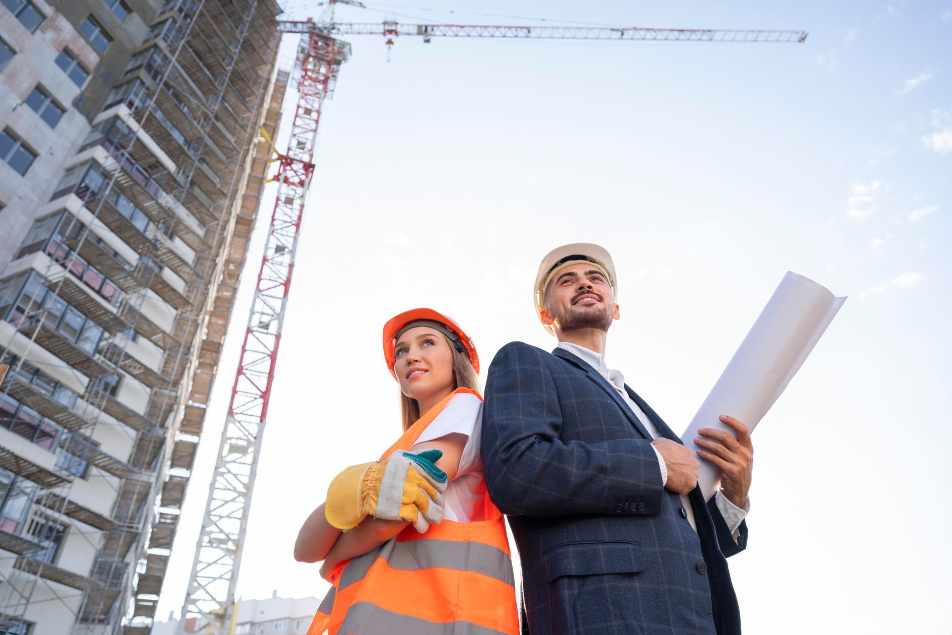 A man and a woman are standing next to each other on a construction site.