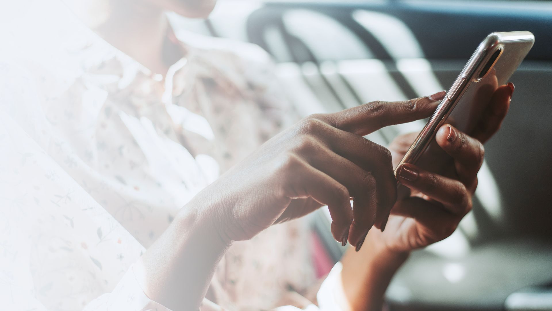 A woman is using a cell phone in a car.