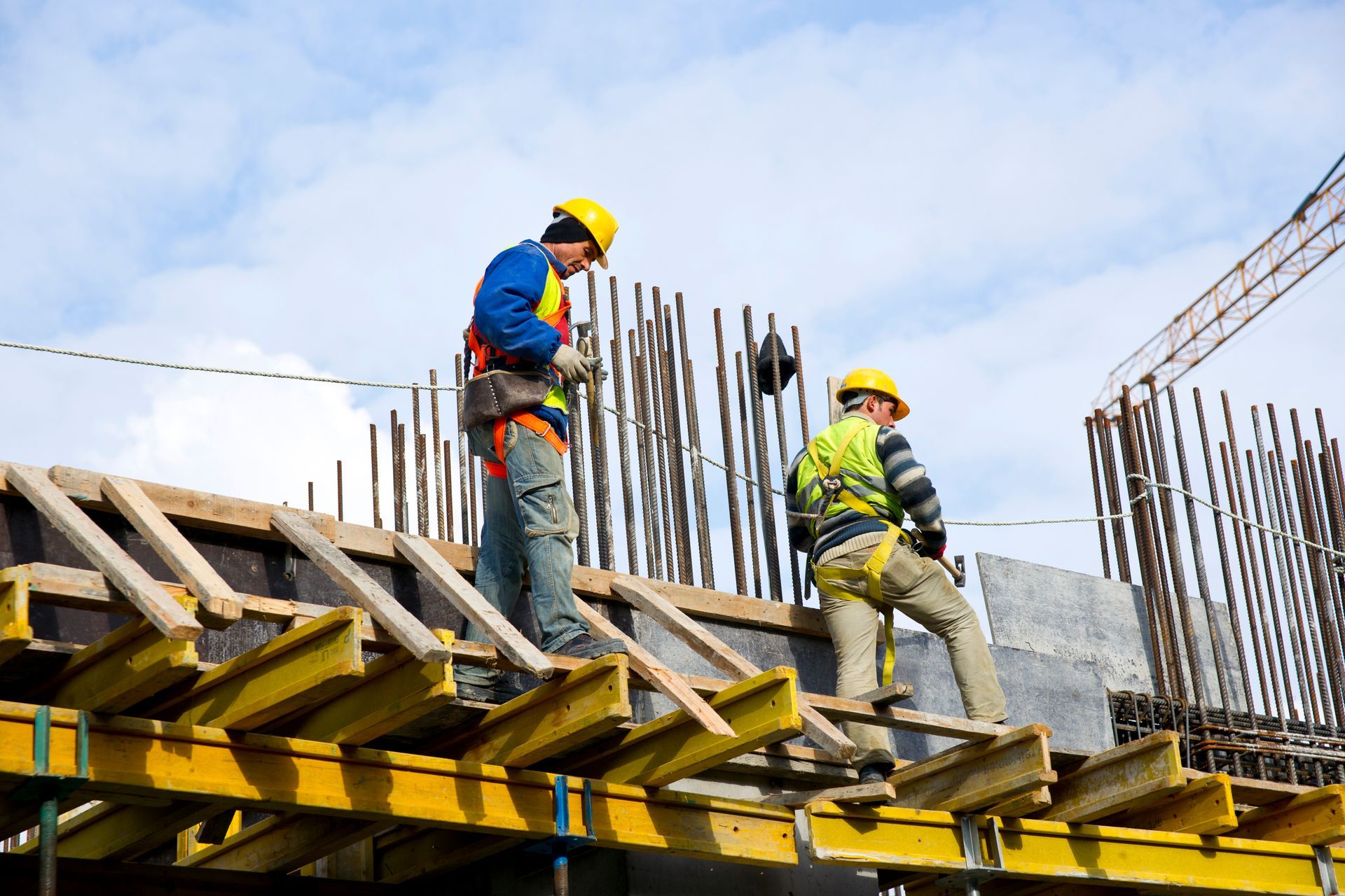 Two construction workers are working on a building under construction.