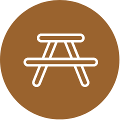 An icon of a picnic table in a brown circle.