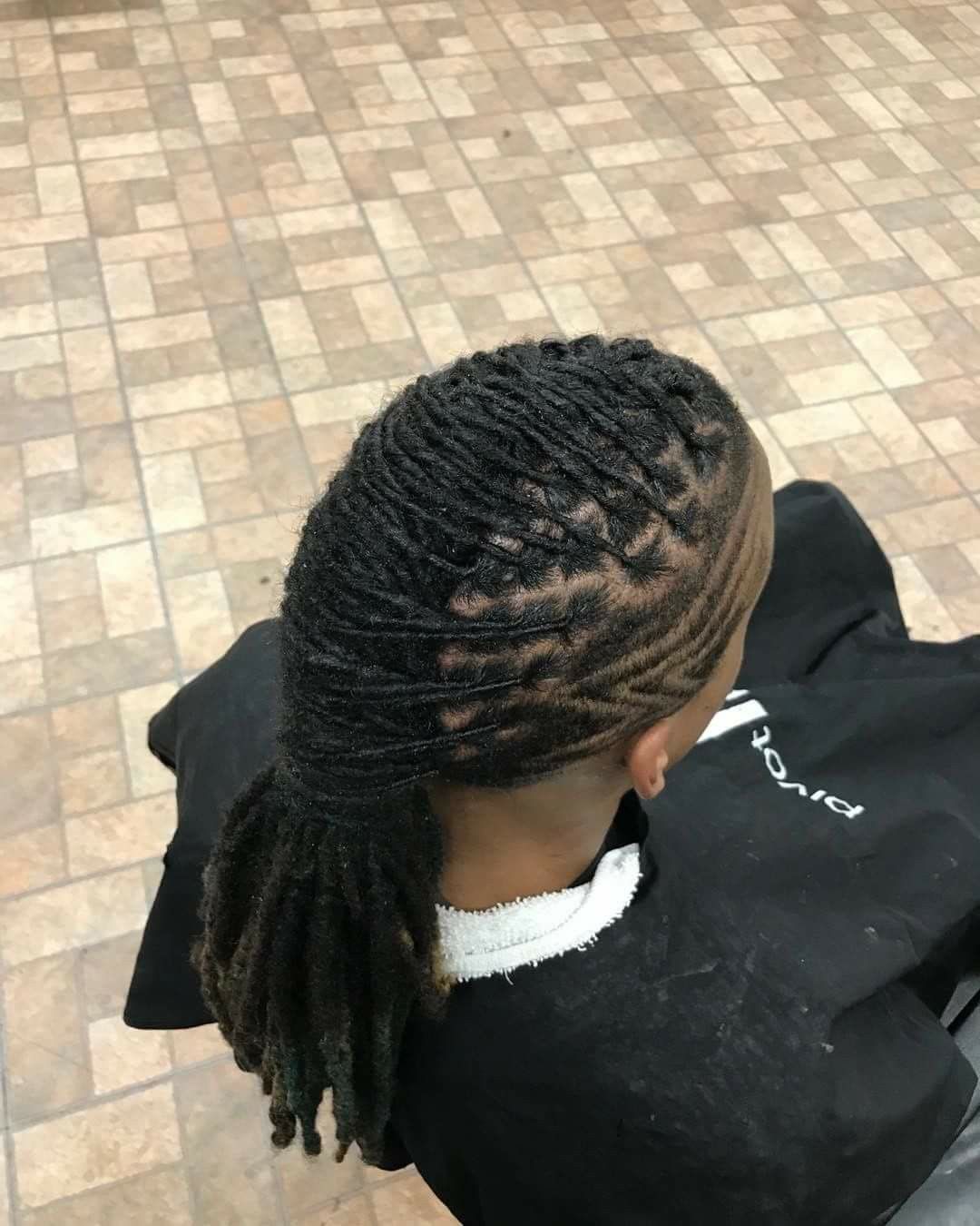 A woman with dreadlocks is wearing a black cape