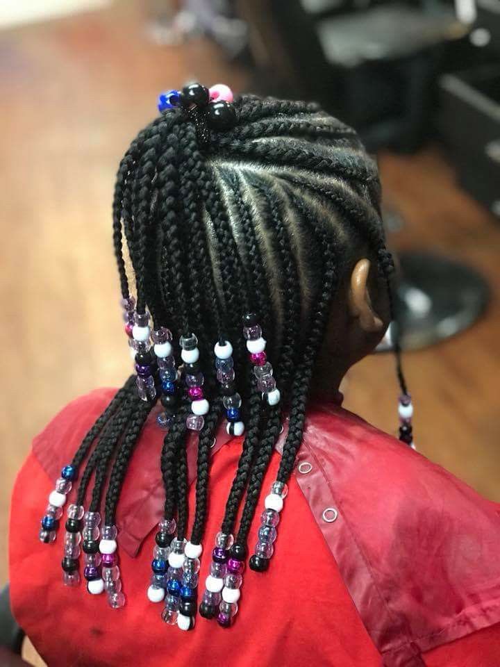 A little girl with braids and beads in her hair
