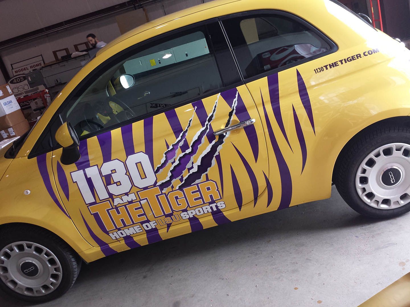 A yellow car with a tiger design on the side