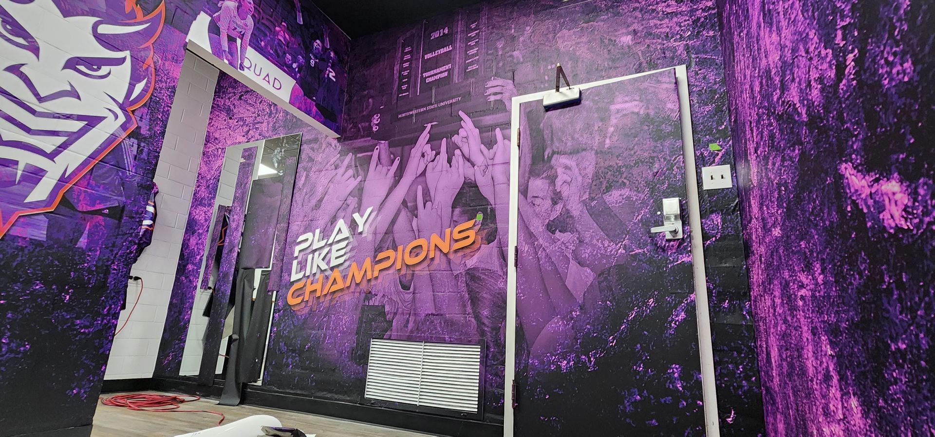 A purple and black room with a door and a mural on the wall.