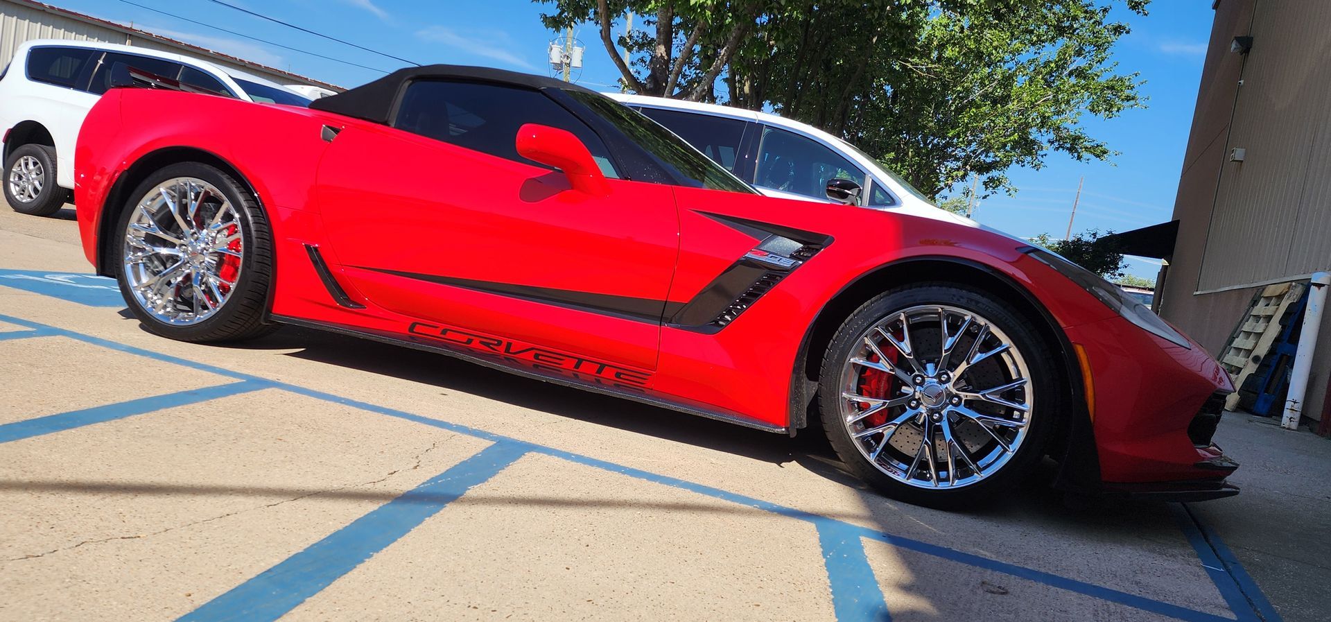 A red sports car is parked in a parking lot.