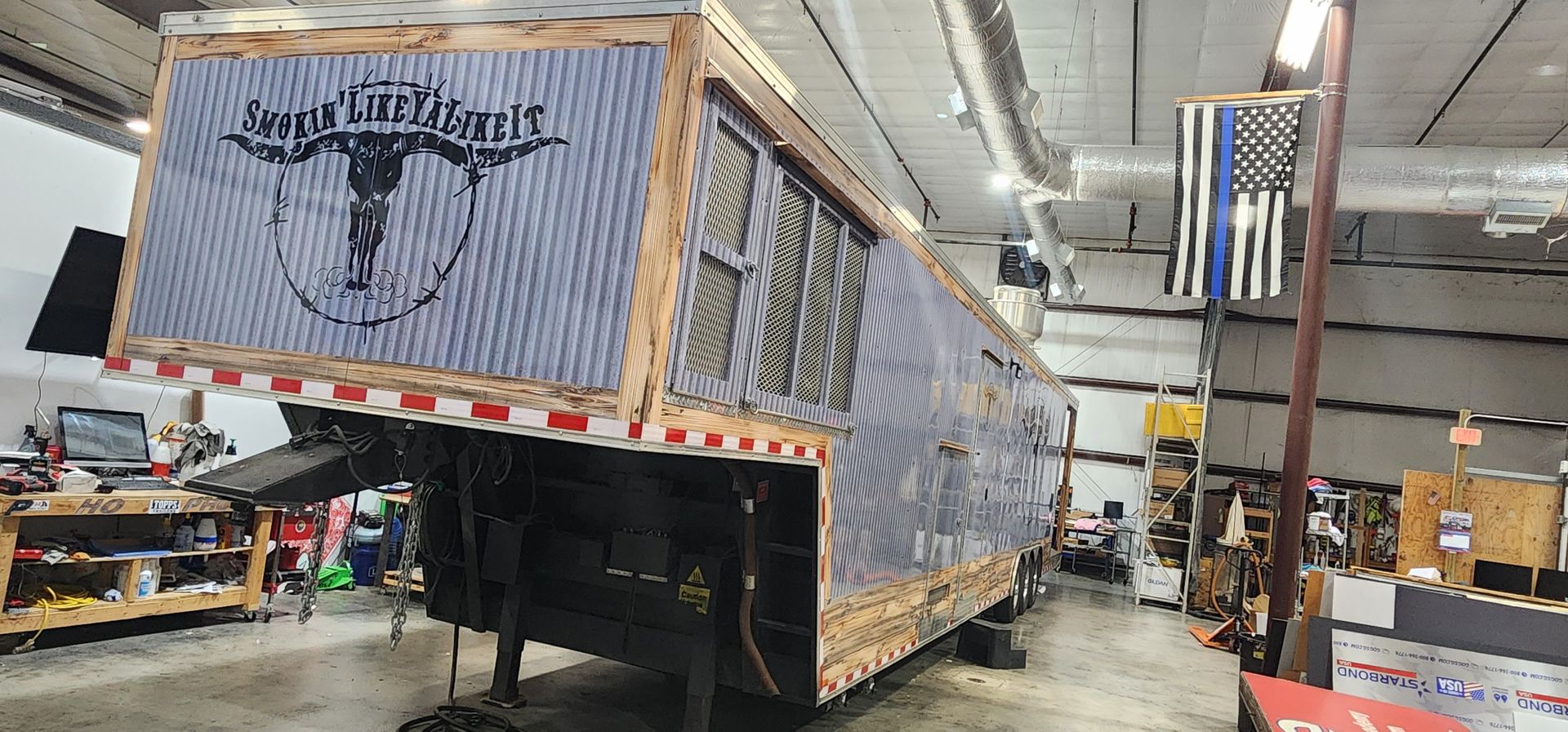 A large trailer is sitting in a garage.