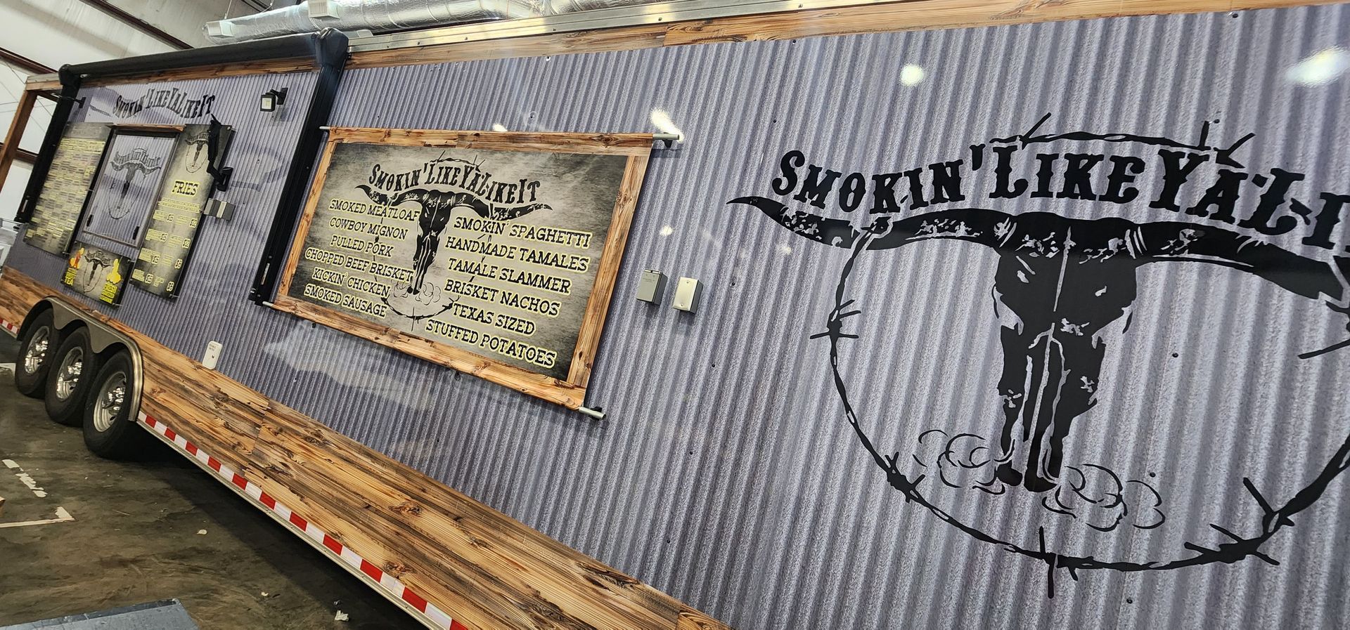 A trailer with a bull skull on it is sitting in a garage.