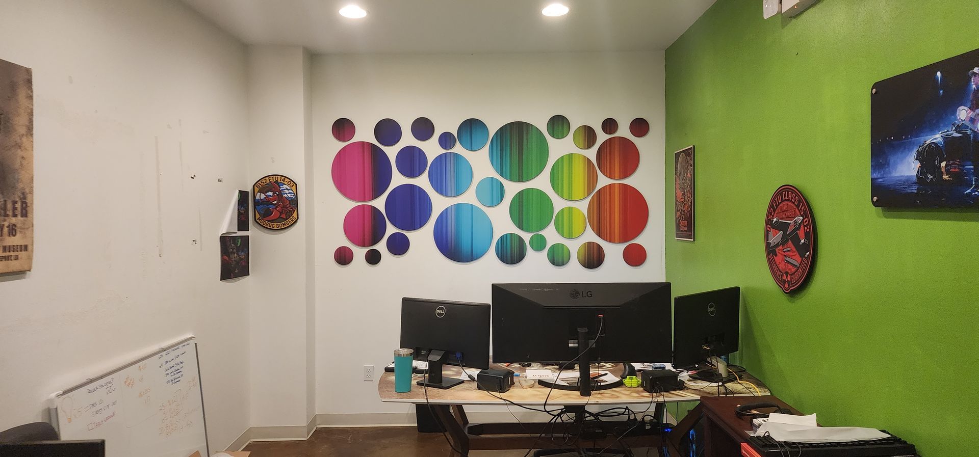 A room with a green wall and a rainbow of circles on the wall.