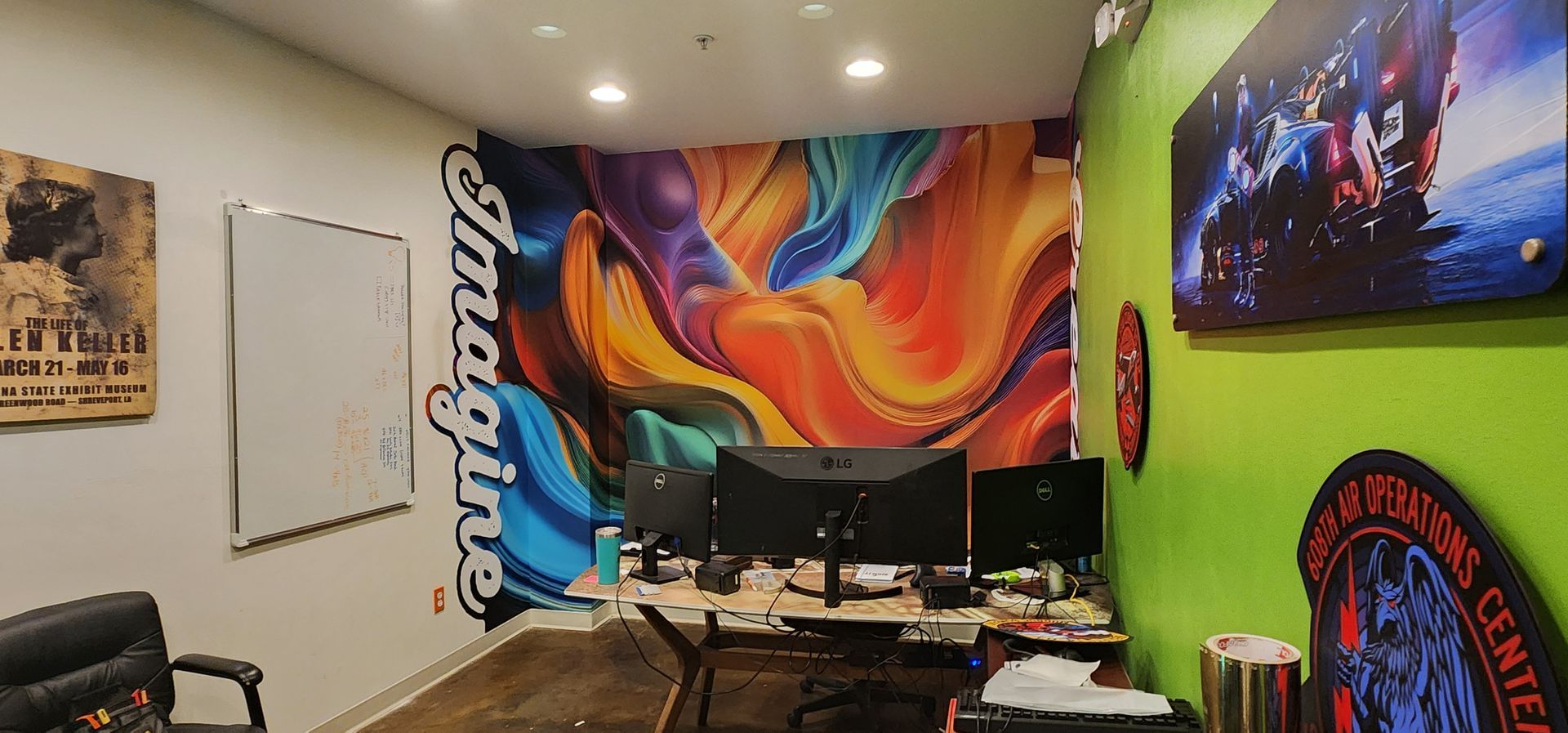 A room with a mural on the wall and a desk and chairs.