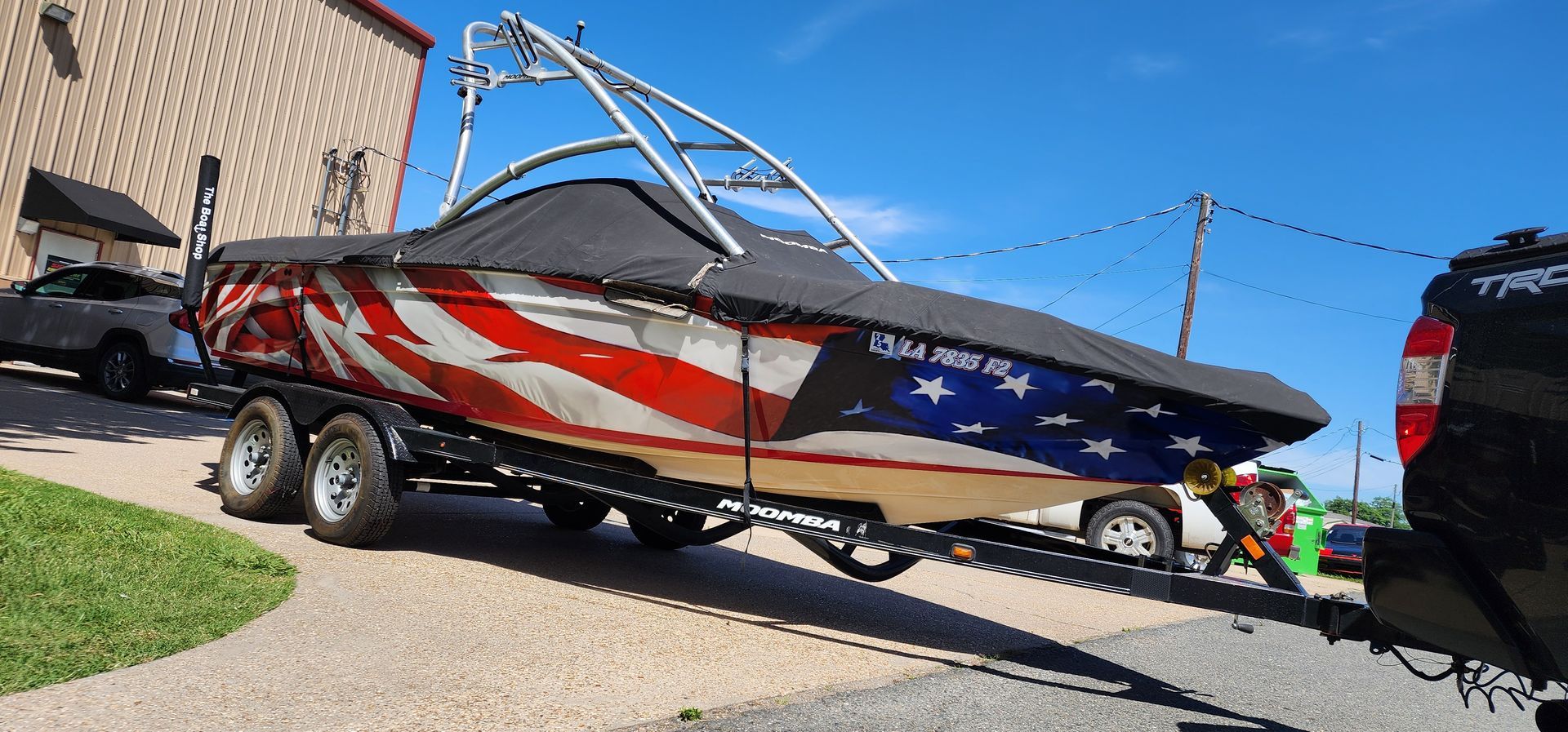 A boat is on a trailer with an american flag painted on it.