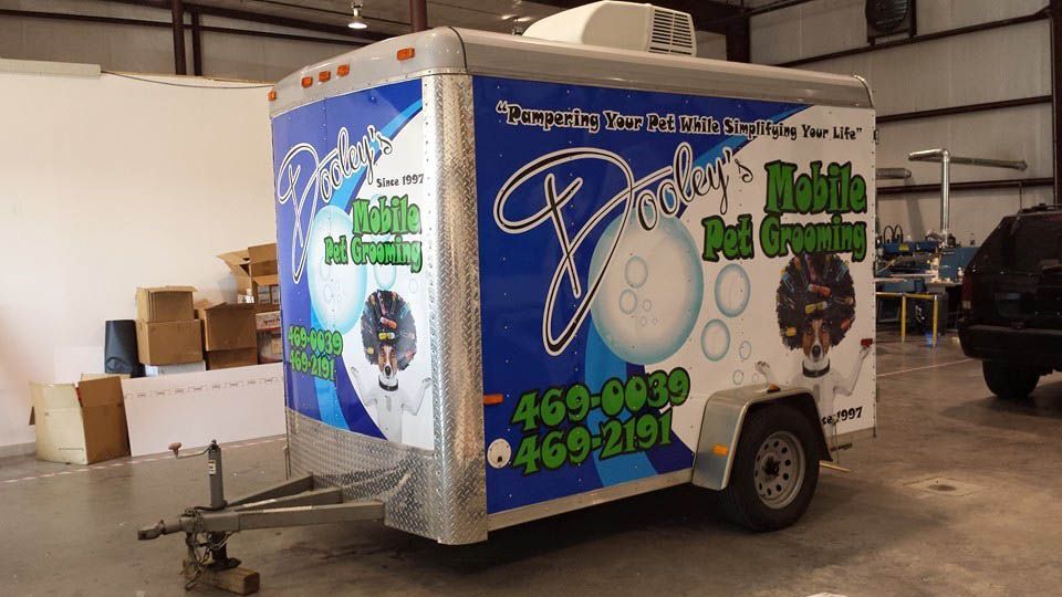 A trailer with a sticker on it that says john 's mobile pet grooming