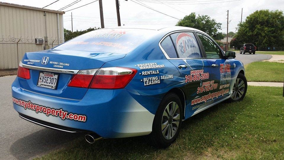 A blue car is parked on the side of the road