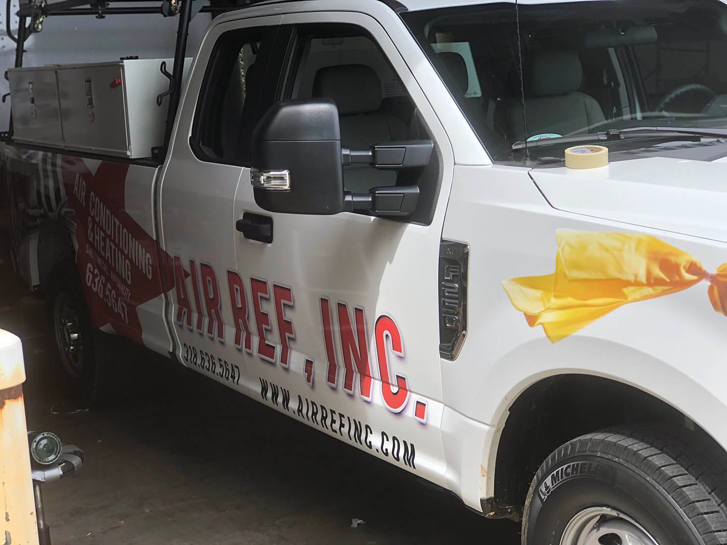 A white truck with the word airref inc on the side