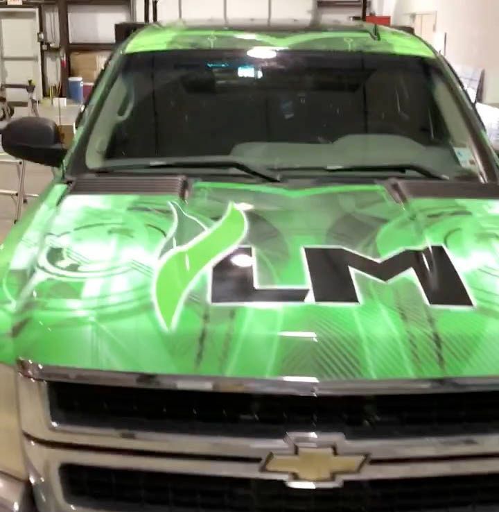 A green chevrolet with the letters lm on the hood