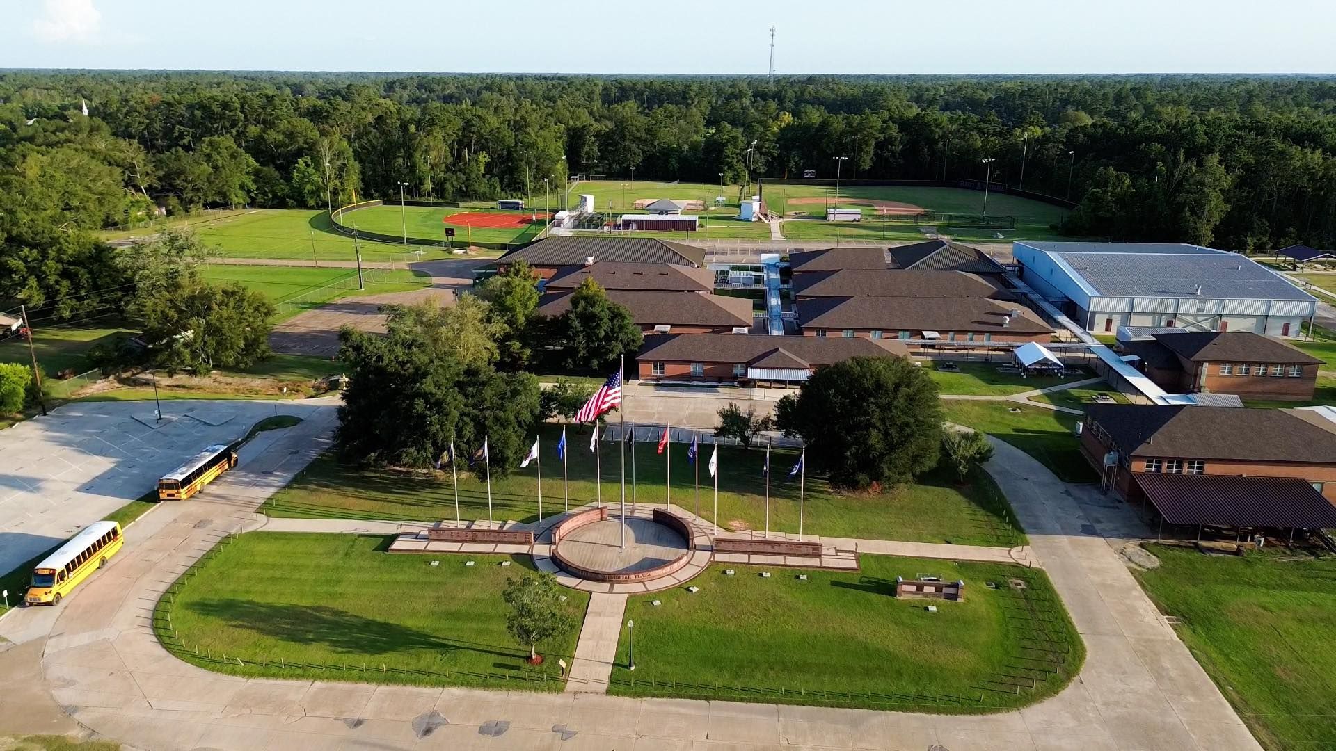 An aerial view of a school with buses parked in front of it