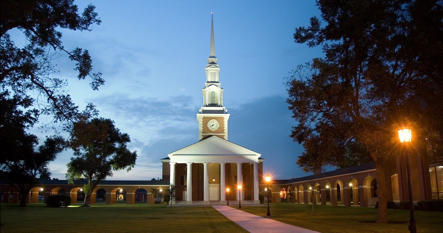 A church with a steeple and a clock tower at night