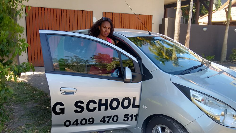 A Woman Is Sitting In The Driver's Seat Of A G School Car — Solitude Driving School In Mooroobool, QLD