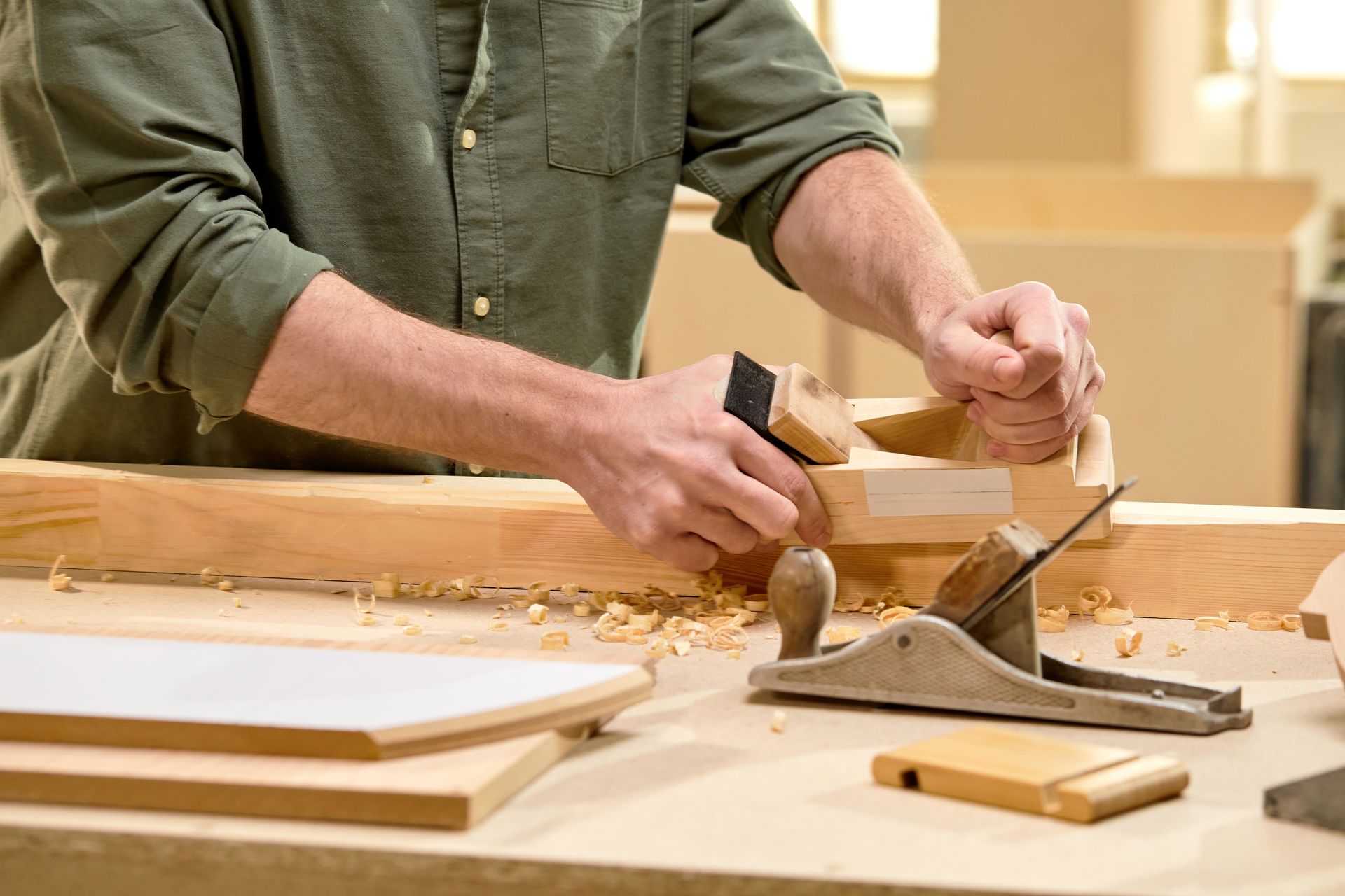 A man is sitting on a ladder working on a door.