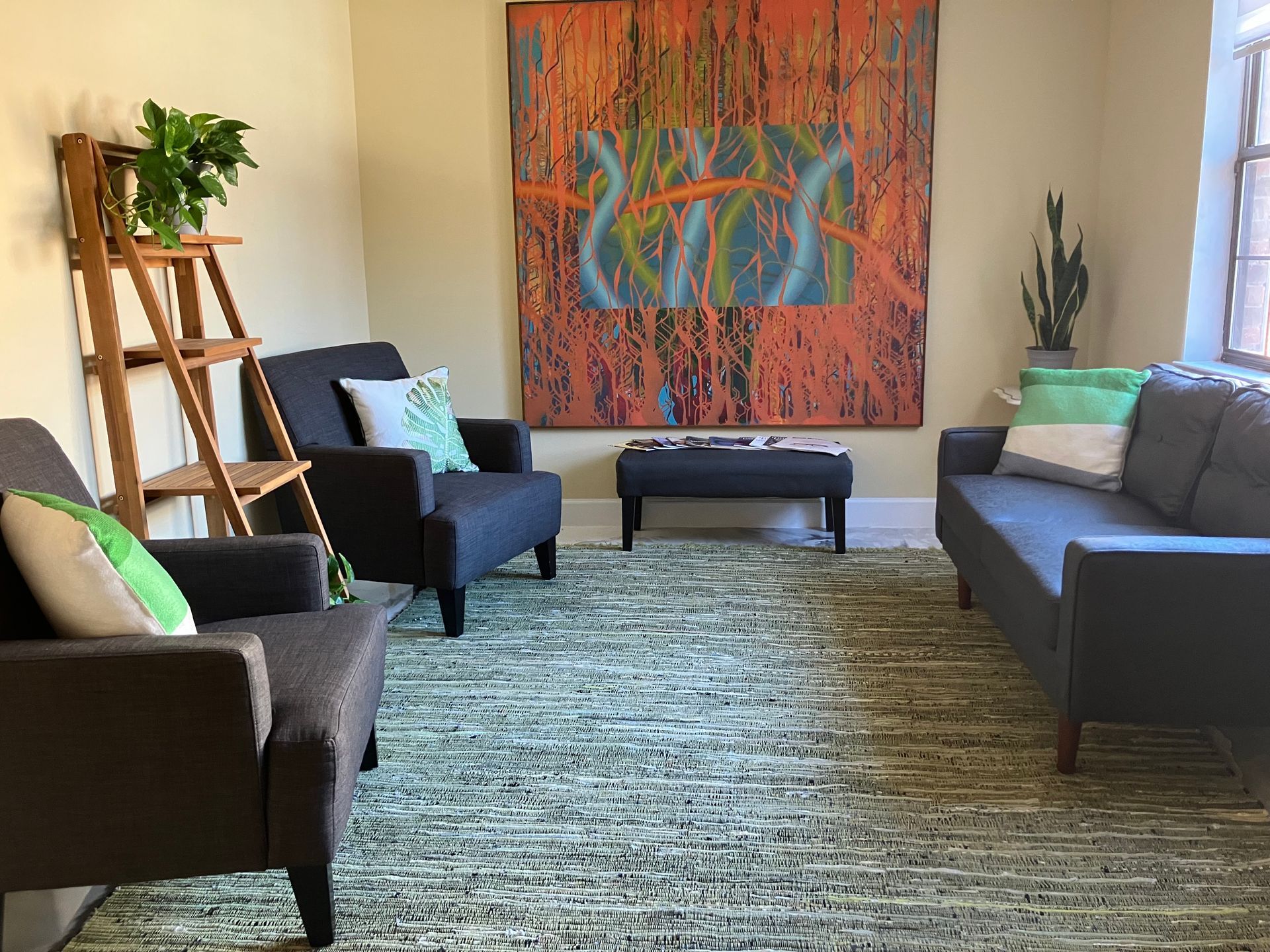 bodywork suite lobby with brown furniture and large artwork, and plants