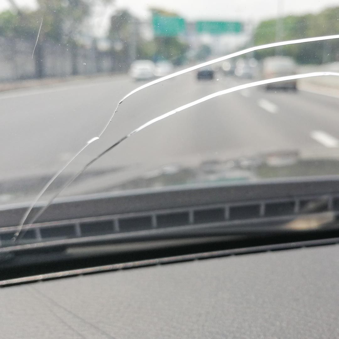 car driving on the road with a cracked windshield