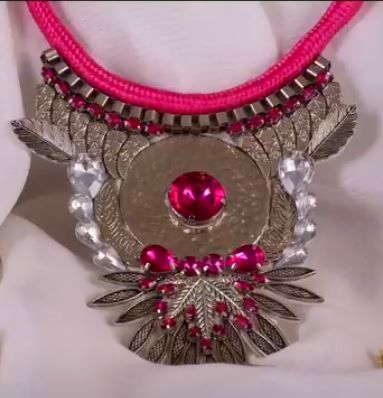 Collar llamativo en color rosa y plata con gran colgante central y cordón a juego.