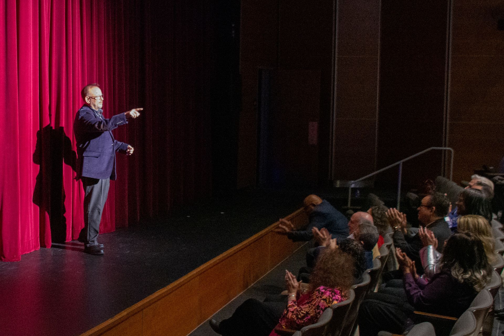 Richard Scully is standing on a stage in front of a crowd of people.