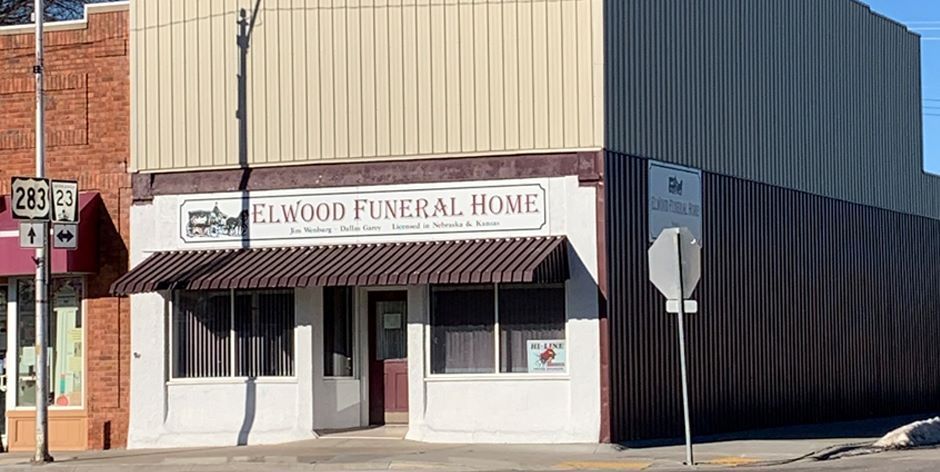 A funeral home is located on the corner of a street in a small town.