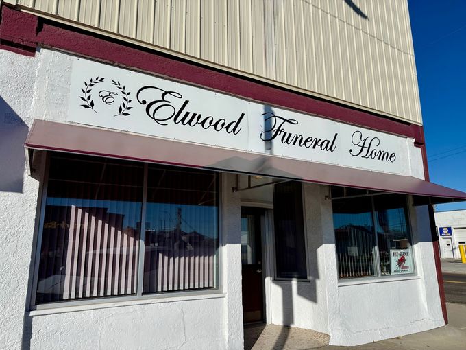 a brick building with a black awning that says funeral home